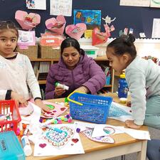 Female Parent doing arts and crafts with two young female students