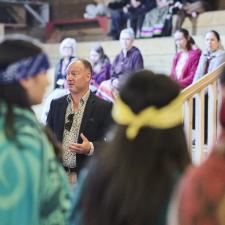 Superintendent Nosek speaks to the standing Indigenous Role Models in the longhouse