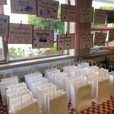 Gift bags lined up with thank you notes hung in front of the window.